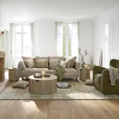 Gemütliches Wohnzimmer mit beigem Sofa, grünem Sessel und Kamin. Tolle Wohnzimmer Ideen für eine warme Atmosphäre.
