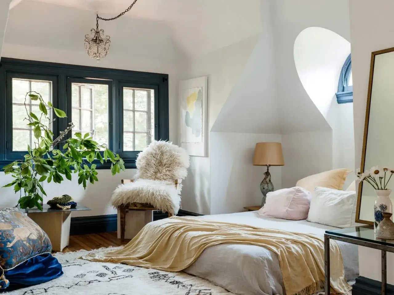 Gemütliches Schlafzimmer mit Lammfellstuhl, gelber Decke und Pflanzen. Tolle Schlafzimmer Ideen für ein entspanntes Ambiente.